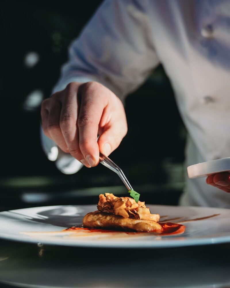 Chef adding the finishing touches to a plate of food