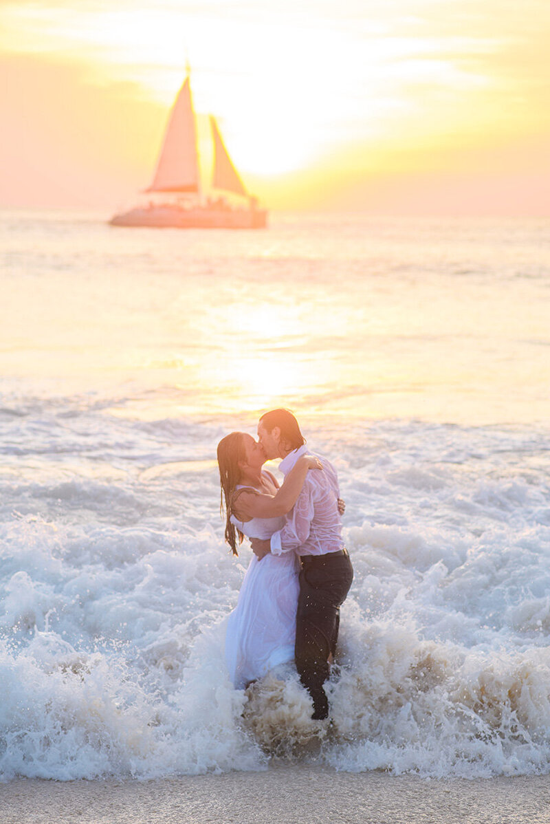Wedding couple at Seattle beach wedding with sailboat and sunset
