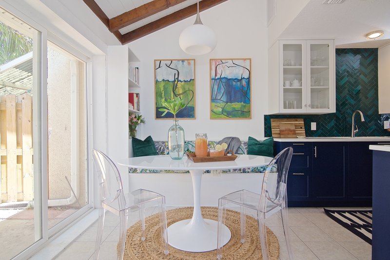 Midcentury modern and bohemian influenced dining room alongside a navy blue kitchen by Denver based interior designer Fernway & Avalon