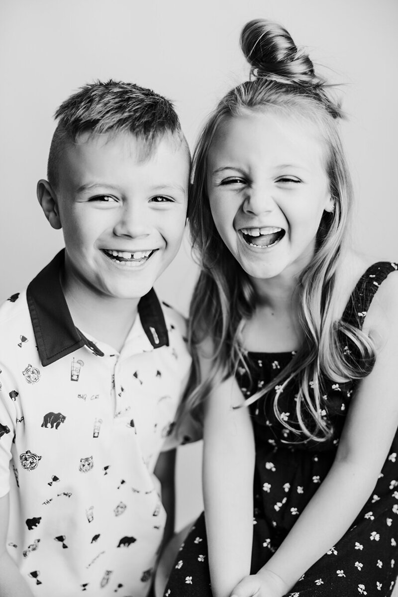 Black and white image of siblings laughing together