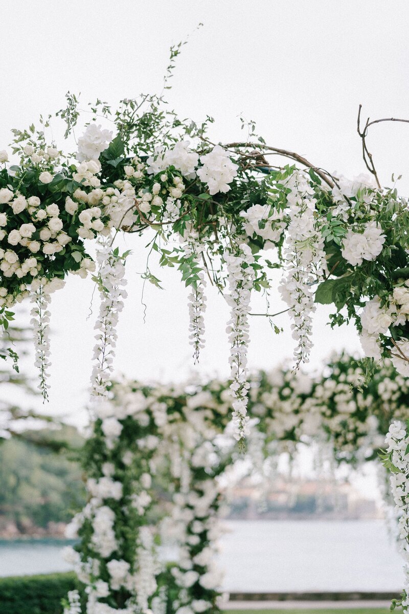 wicker-wedding-arch-decorated-with-roses-wisteria-green-leaves
