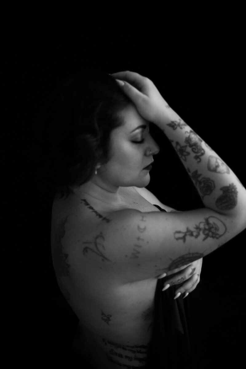 Dettaglio di una donna in lingerie color nero, luce morbida e texture raffinate, in un servizio fotografico boudoir esclusivo