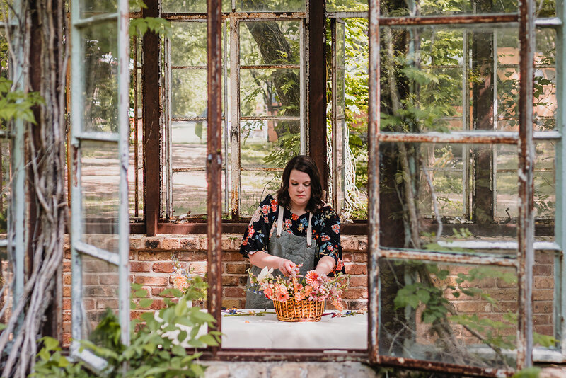 Florist working in Sekrit Theater greenhouse during branding session in Austin, TX.