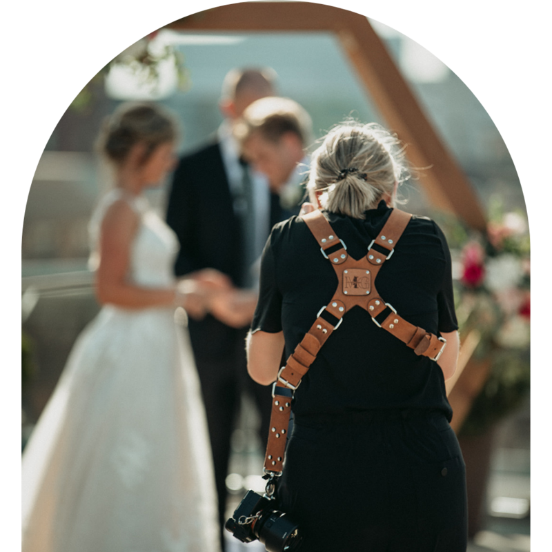 Mallory taking a photograph of a bride and groom at their wedding ceremony