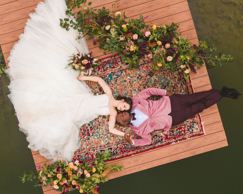 bride and groom laying on dock