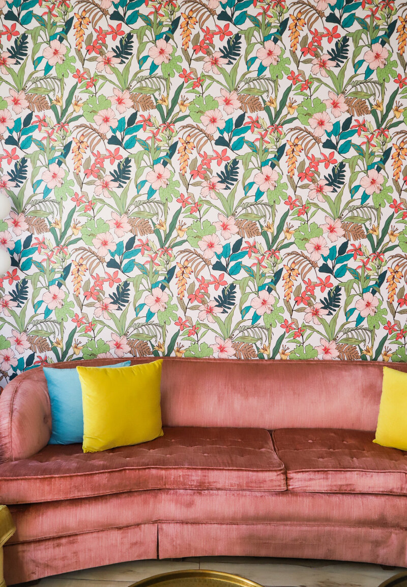 pink vintage sofa against floral wallpaper
