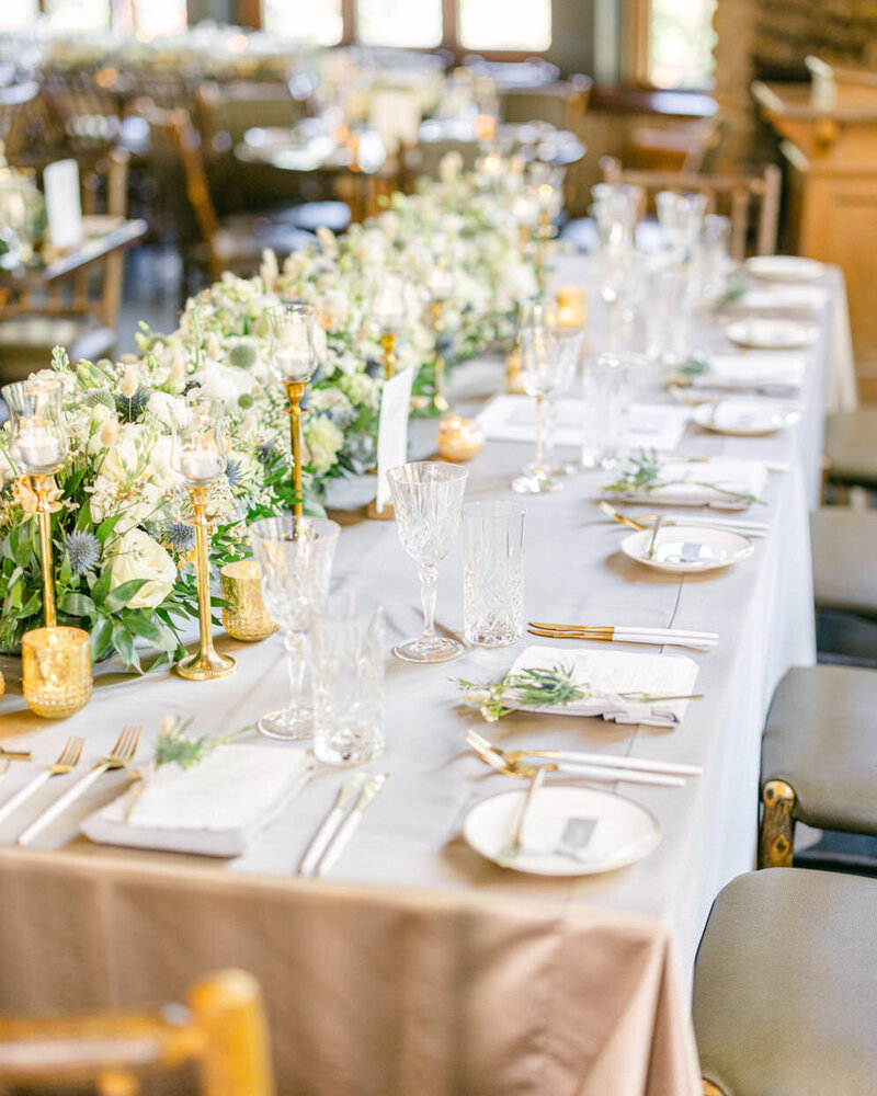 This stunning photograph captures the head table setup and elegant room details at a River Café wedding reception in downtown Calgary, highlighting the venue’s warm ambiance and charm.