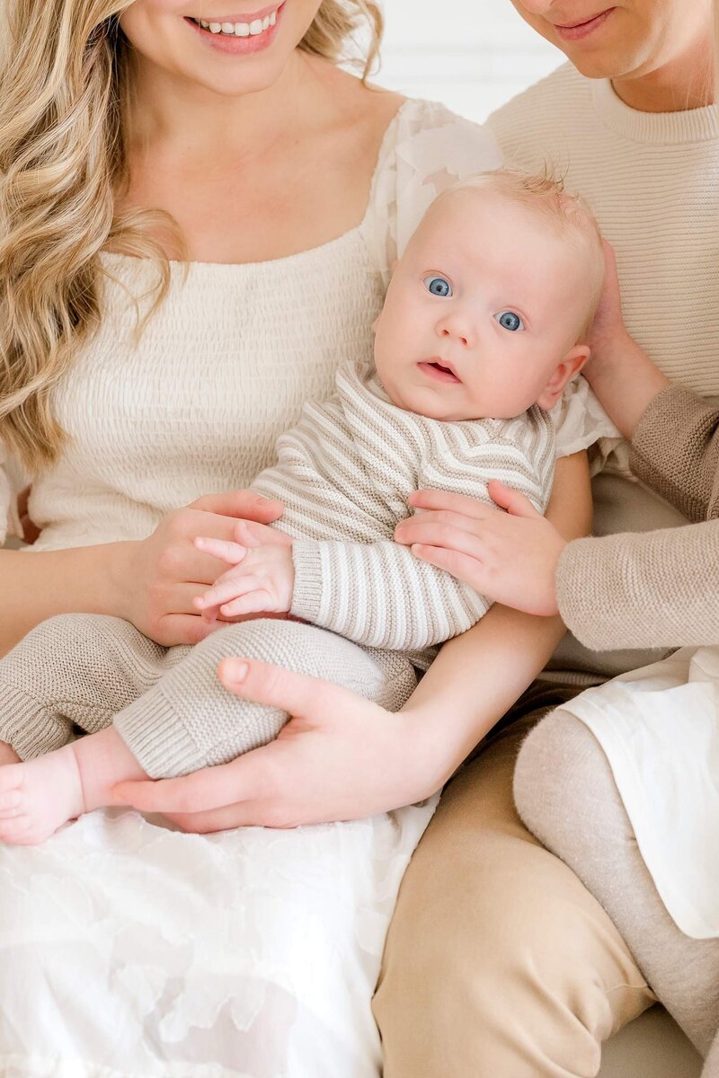 Newborn  stares off into the distance while wrapped in blanket during Minnetonka family photoshoot.