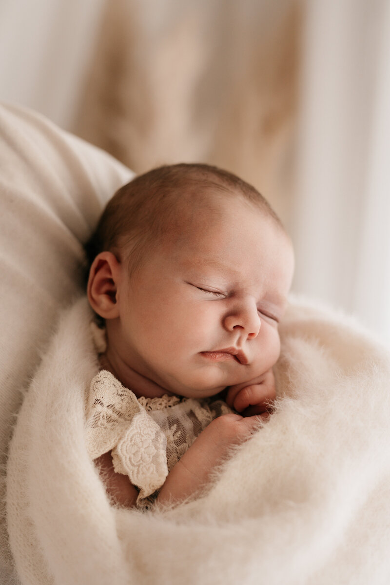 Photo of a newborn baby wrapped in a fluffy blanket