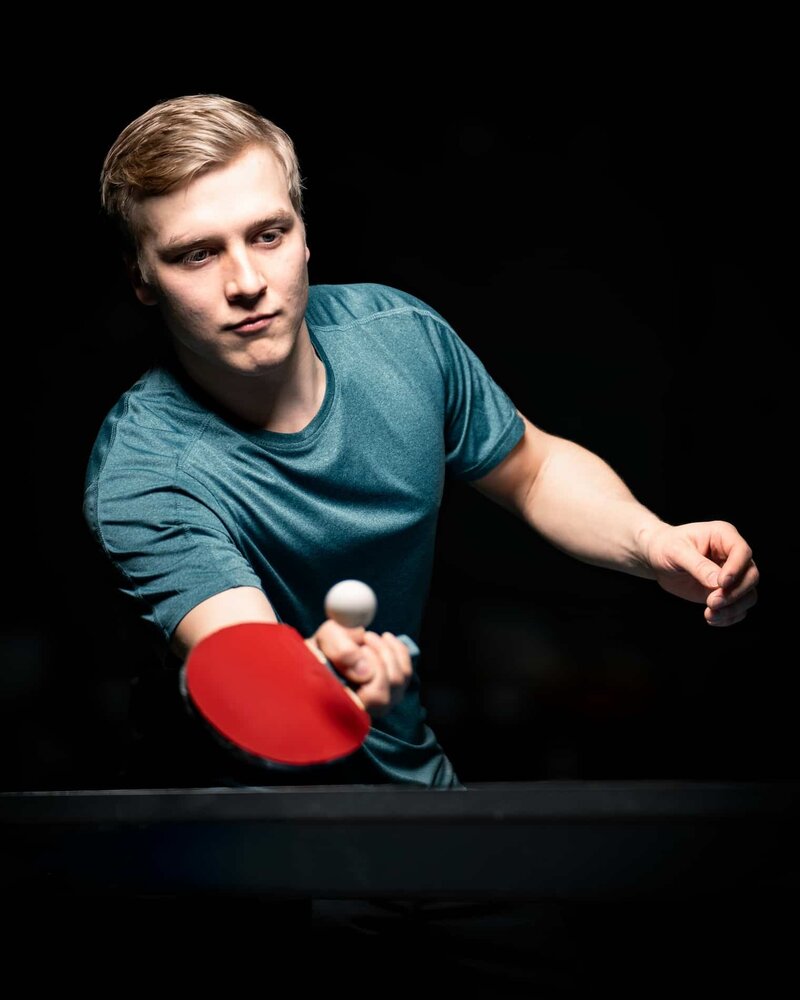 Sportporträtt av en bordtennisspelare som slår bollen