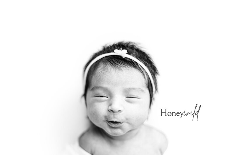 Newborn photographer in Grand Rapids captures swaddled baby smiling with headband