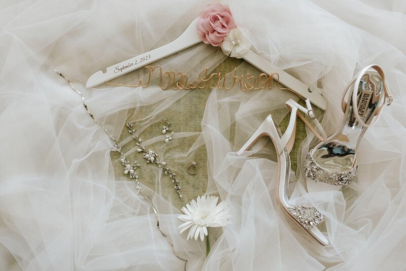 A wedding dress, shoes and flowers on a table.