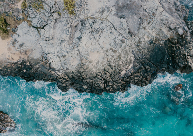 Drone Wedding Photographer captures blue water crashing against Hawaii cliffs