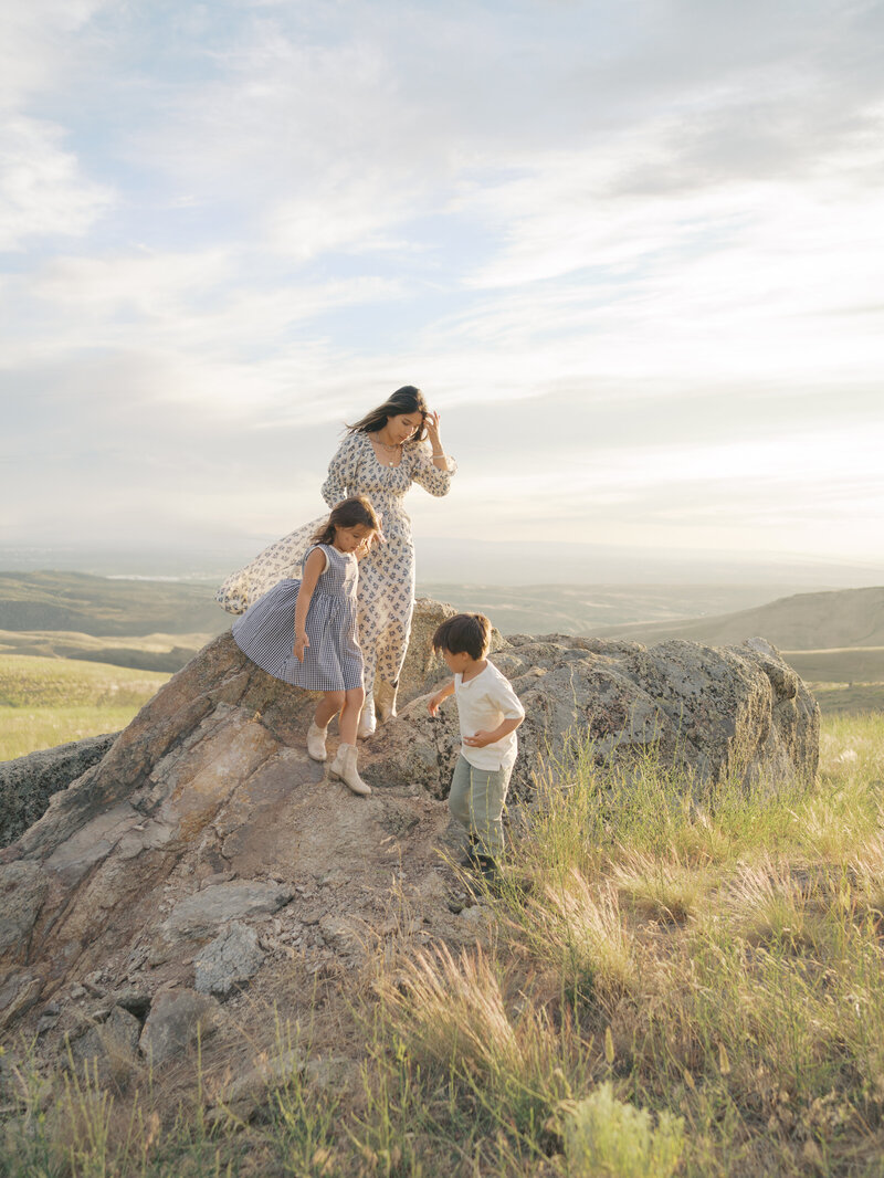Mom with kids climbing down rock taken by Colorado Springs Family Photographer | Lauren Bounds