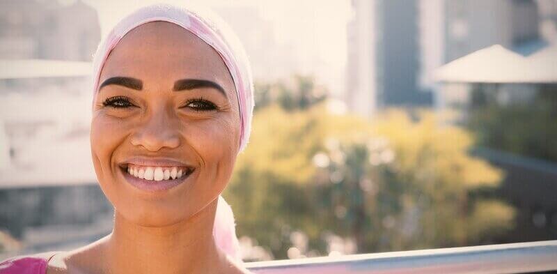 Woman smiling with head scarf on.