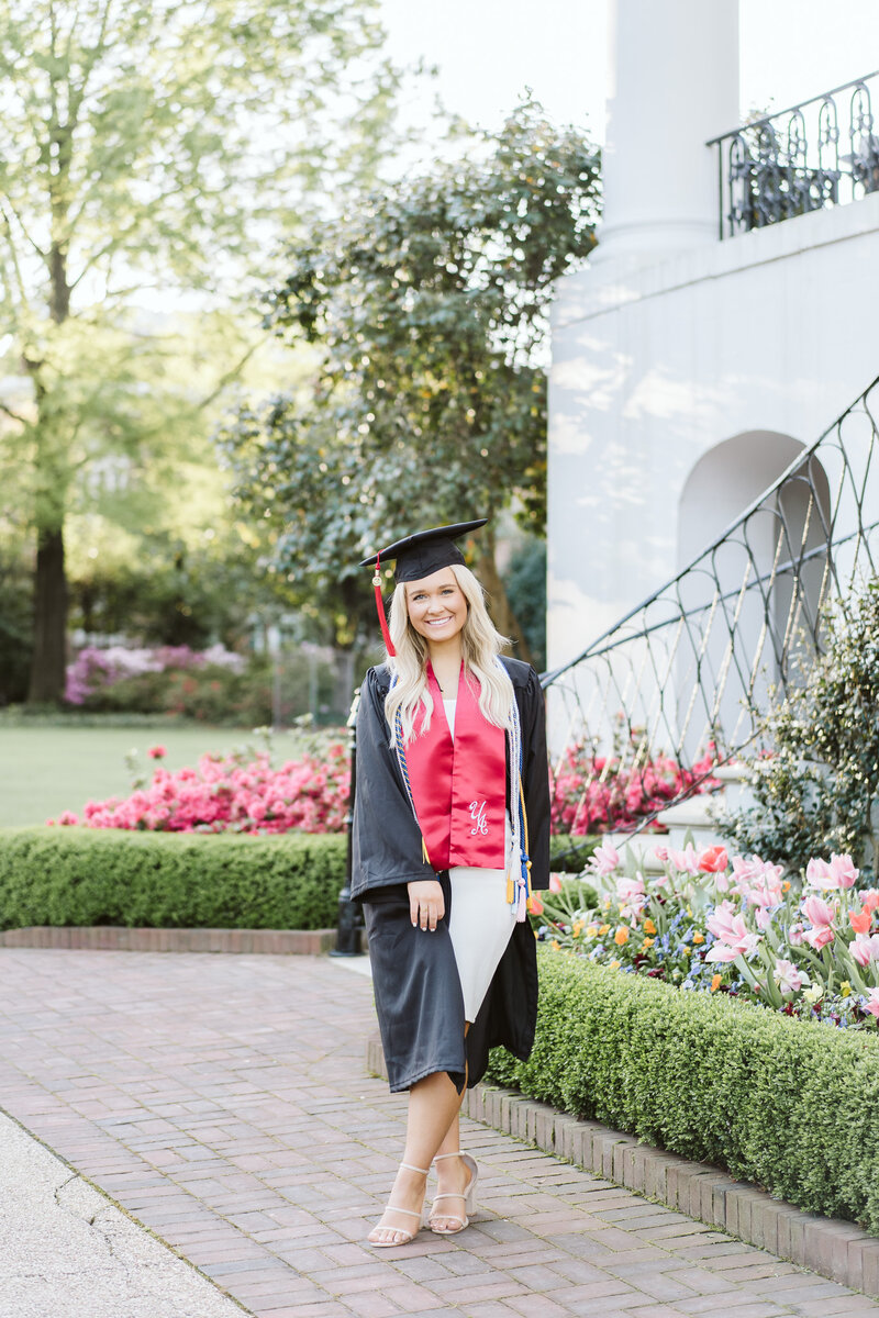 a graduate in her cap and gown at the president's mansion