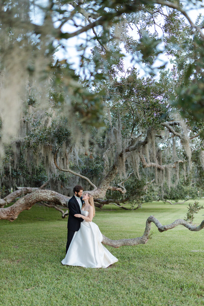 bride and groom gazing into each other's eyes under Spanish Moss oak trees