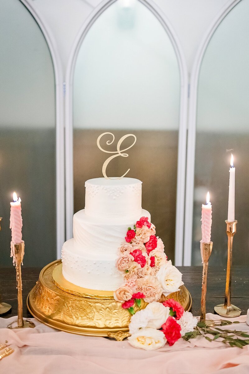 Wedding cake with pink florals and candles | New Water Farms Wedding Photography