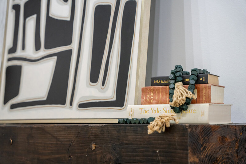 white and black art above console with books and decor