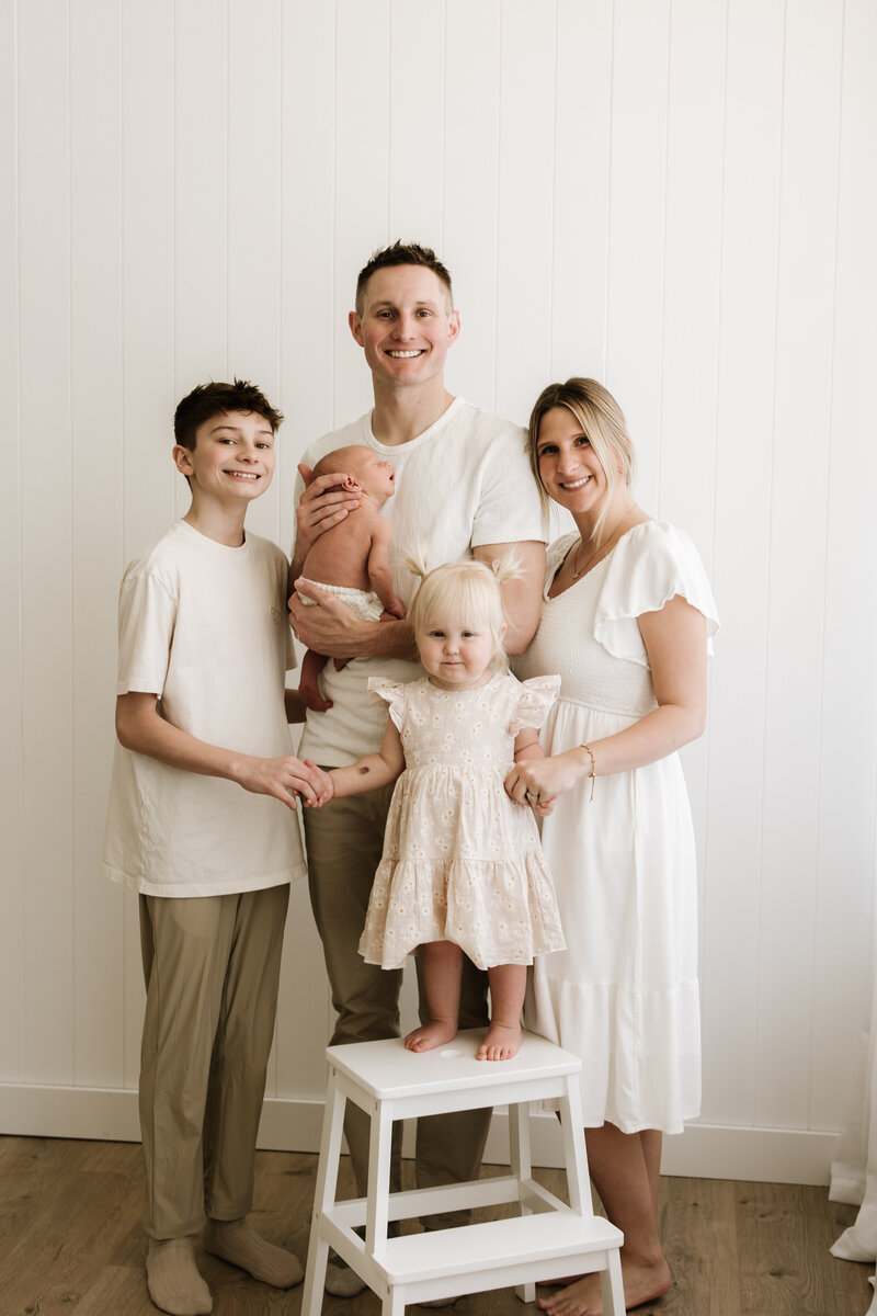 new family sitting in nursery with dog