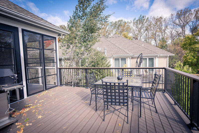 Low-maintenance deck with an outdoor dining set and aluminum picket railing. 