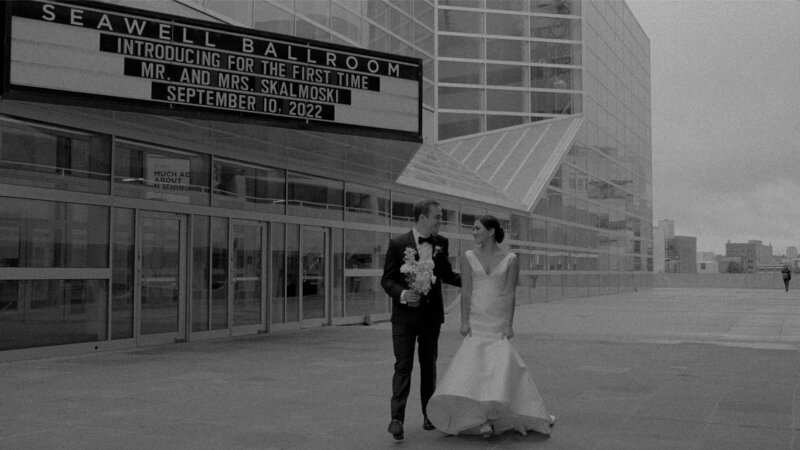 couple in black suit and wedding dress standing in front of seawell ballroom