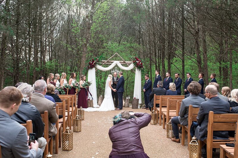 Behind the scenes photo of Mahlia taking photos during the ceremony at a wedding at Drakewood Farm
