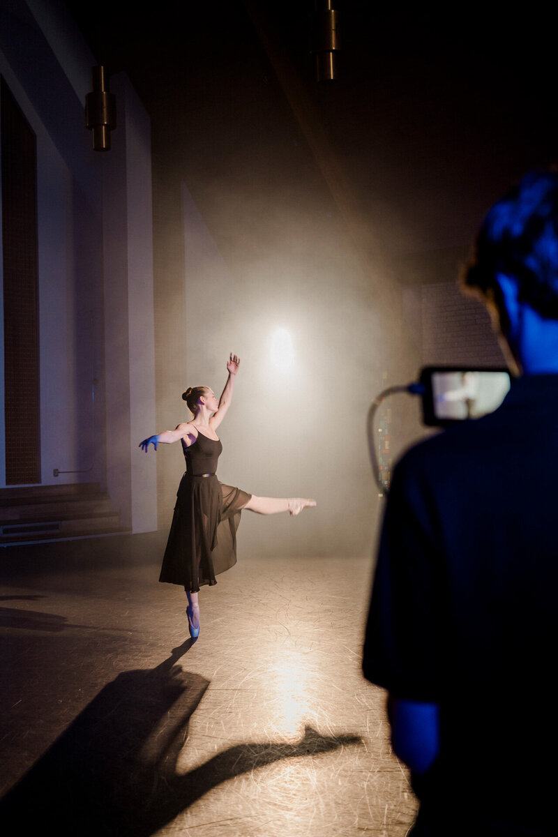 a ballerina in a black dress performs for a storyteller studios camera operator