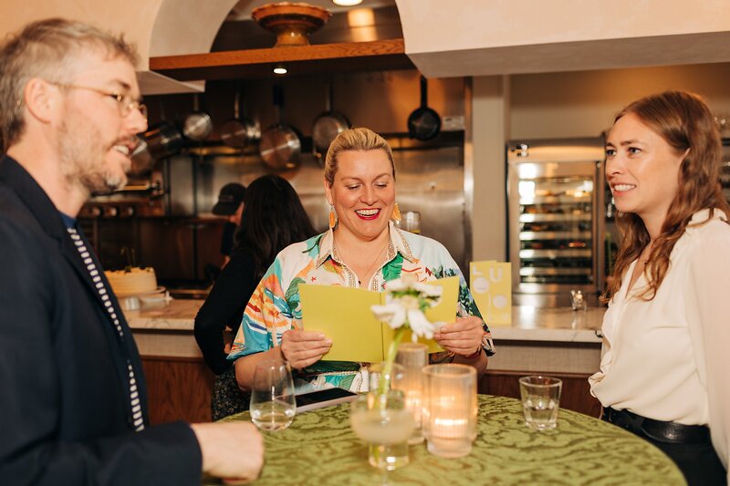 Guests enjoying cocktails and music surrounded by Fleur floral arrangements during Dart Collective Chicago launch at Lou Lou by Lola Cafe