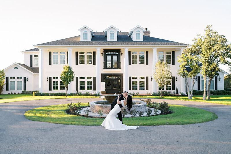 bride and groom kissing in front of wedding venue