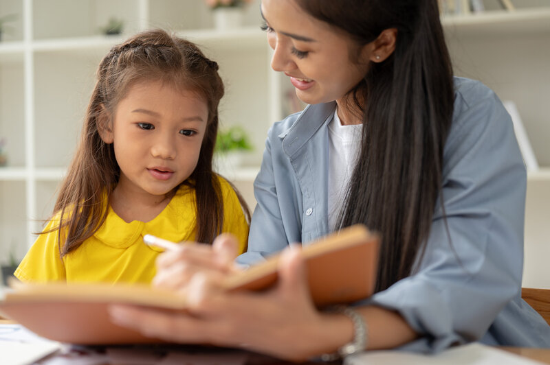 first grade student reading with teacher