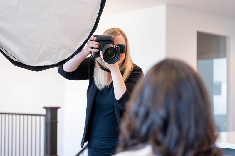 Portrait of Sara Vaz holding her camera taking a picture with her Canon camera.