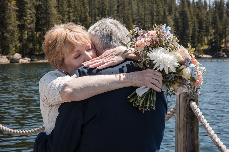 Bride and groom embracing after first look on dock of Lake Coeur d'Alene.
