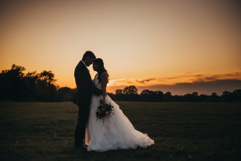 Bride and groom pose for portrait at sunset