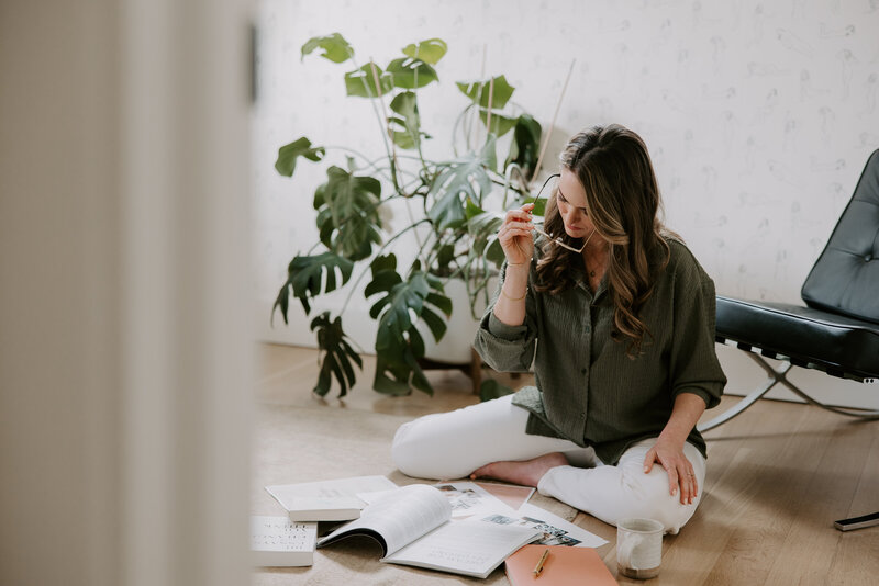 A SEO website copywriter sitting on the floor with a magazine