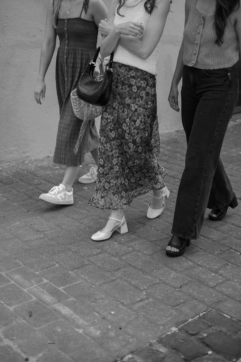 Black and white image of women walking down a sidewalk