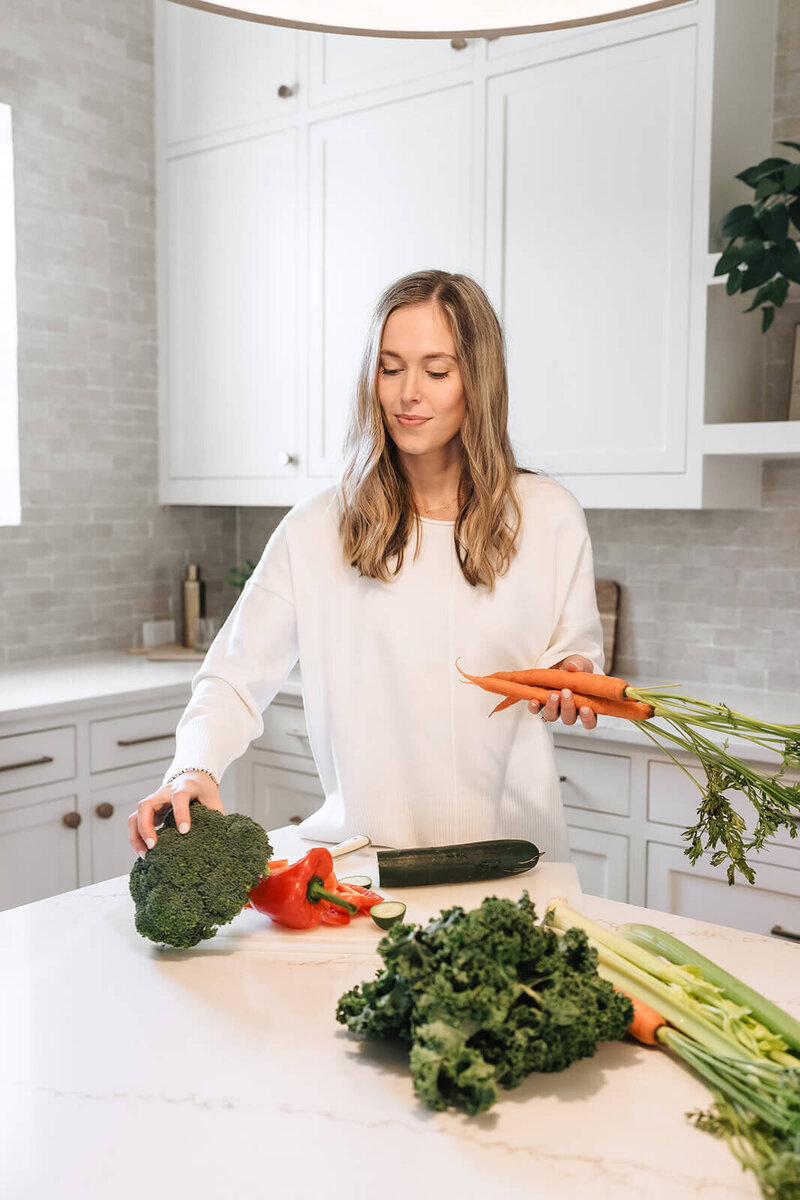 Erica Taylor preparing fresh vegetables in the kitchen—real-life nutrition guide for moms seeking energy, balance, and flexibility around food