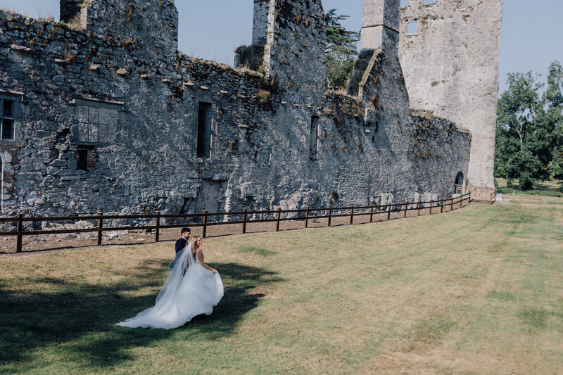 bride-and-groom-walking-by-irish-castle-cork