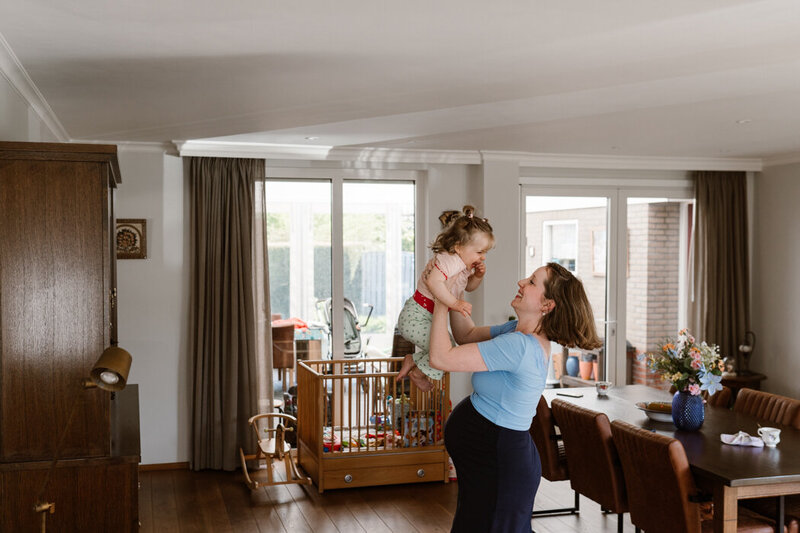 Zwangere mama danst met oudste dochter door de huiskamer