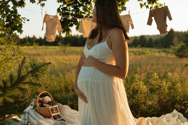 woman holds baby bump during lifestyle session in pei