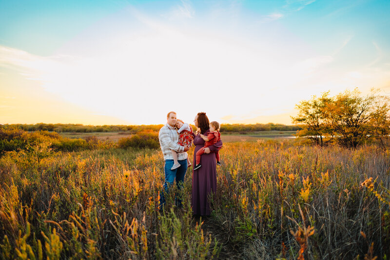 Experience unforgettable family photo sessions in Albuquerque with this stunning image of a joyful family in a lush, expansive forest. Dressed in stylish boho outfits, they radiate happiness and togetherness, making for a memorable and enchanting portrait.