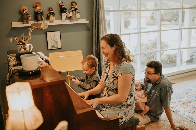 Enjoy a candid family photography session with Light By Zoey in Champaign-Urbana, IL, capturing the joy of playing piano together. Perfect for preserving special family moments in a relaxed, natural setting.