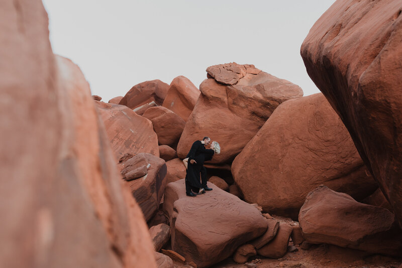 Couple embraces among red boulders in Moab Utah