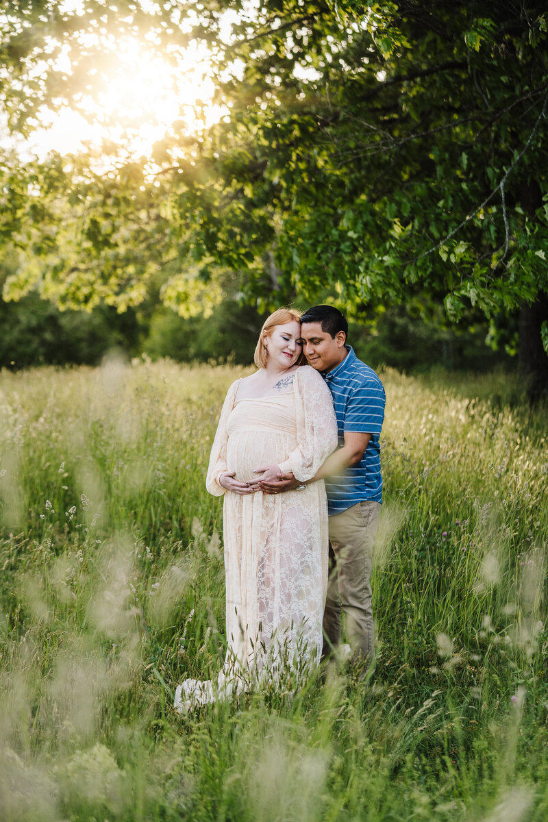 pregnant couple in long green grass