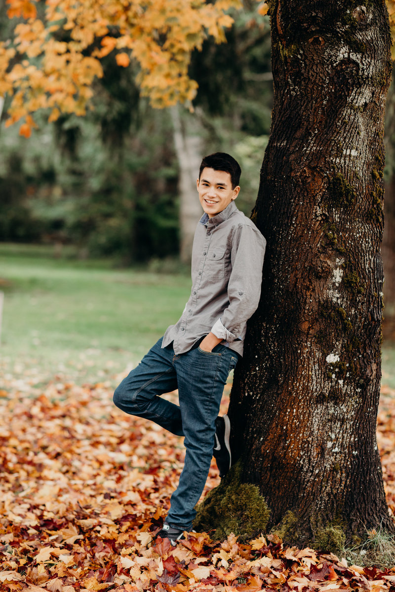 Young man posing by a tree at Fall.