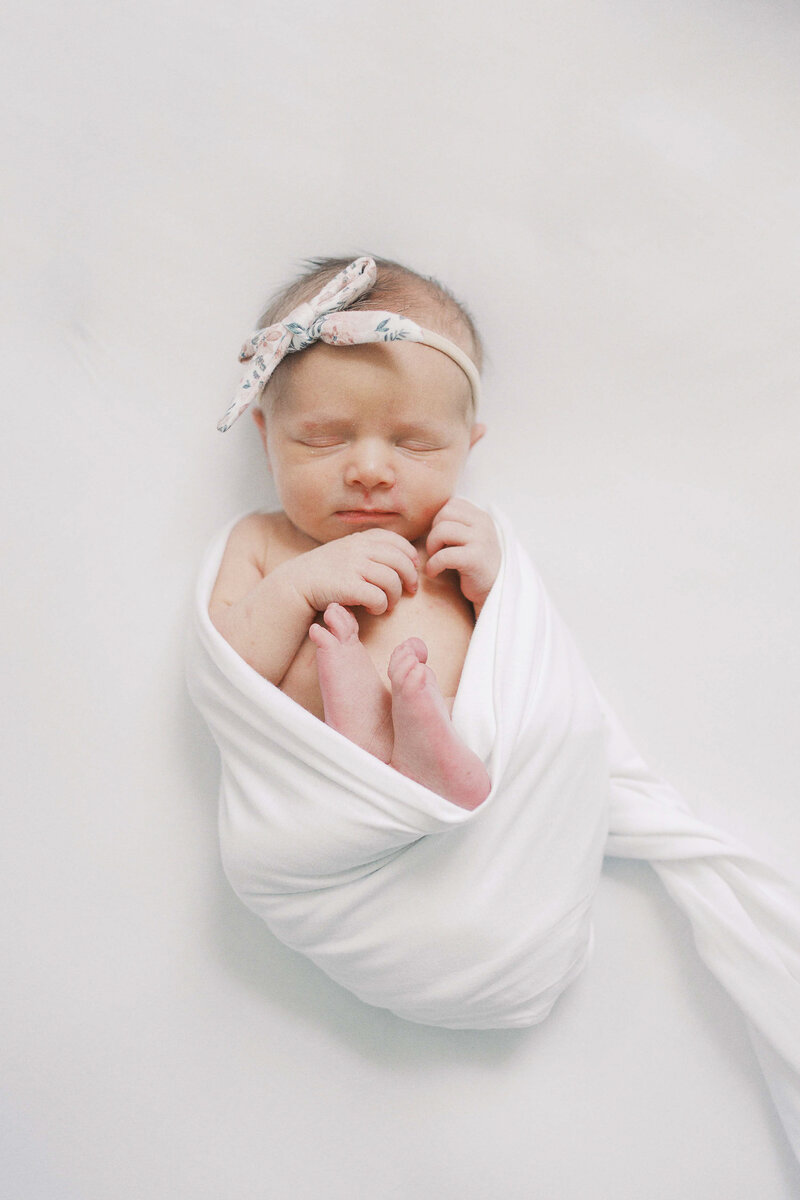 a newborn baby girl wrapped in a swaddle
