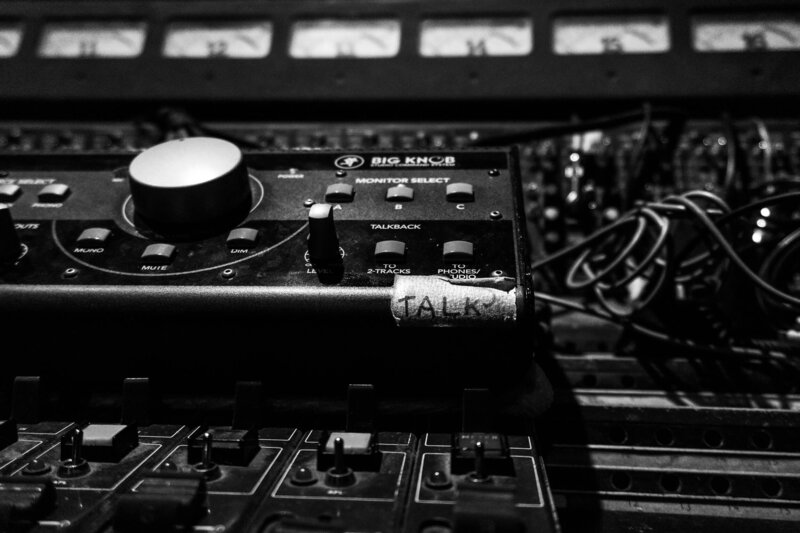 Black and white photo of music studio board equipment with talk tape button