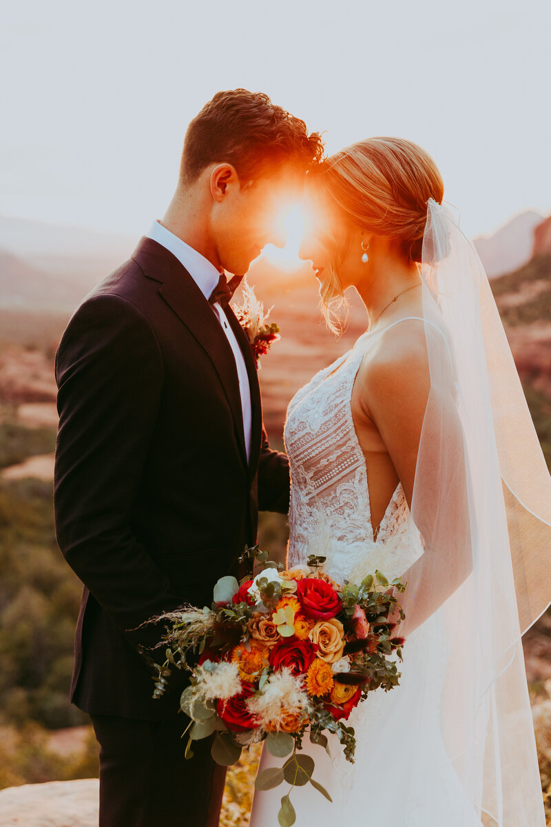 bride and groom with sunset behind them in sedona