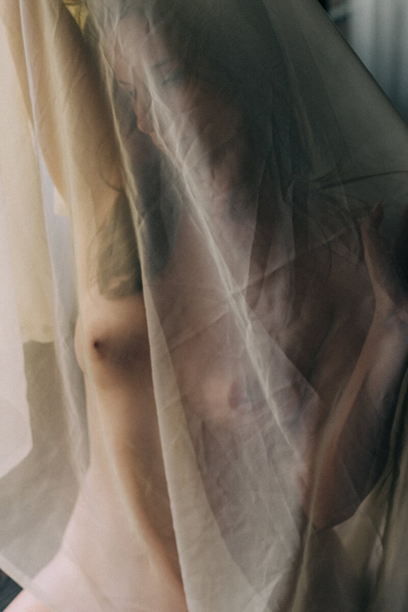 woman with a sheer white drape covering her body