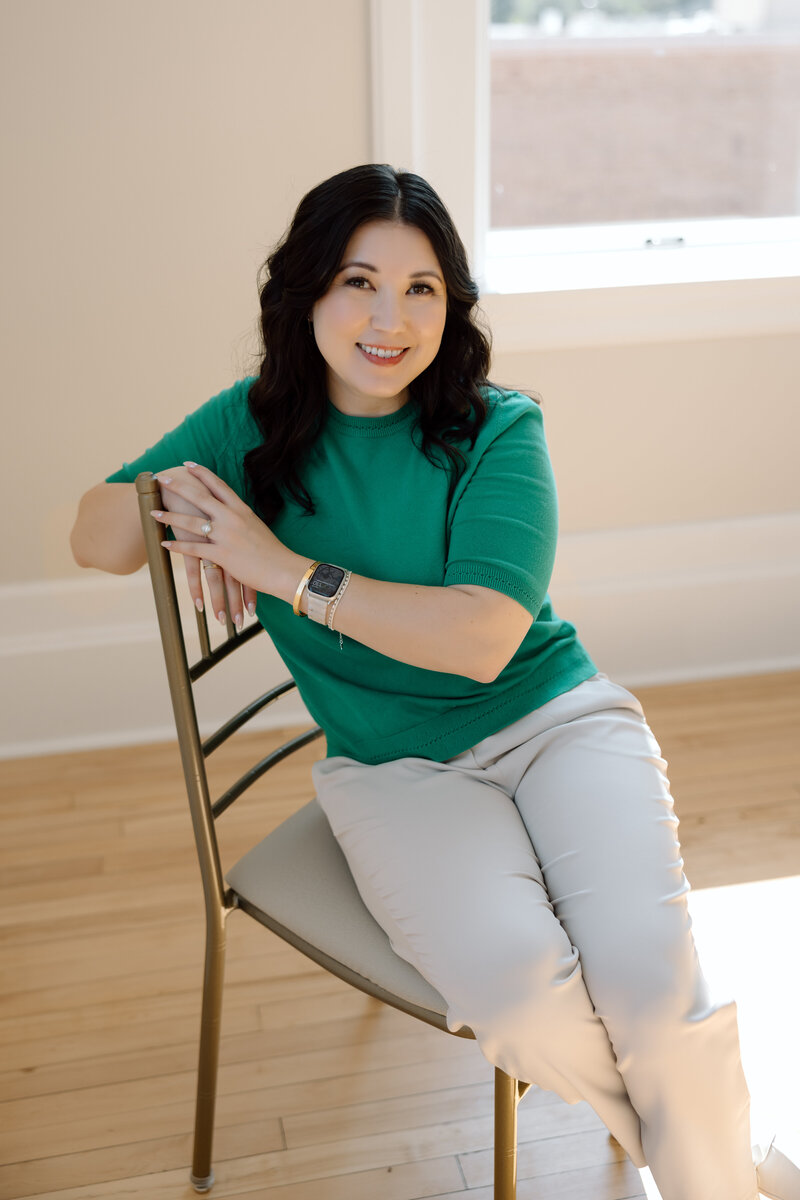 Shanté Gorman, founder of Sugarpunch Marketing®, a social media agency for service providers, sitting on a chair and smiling at the camera.